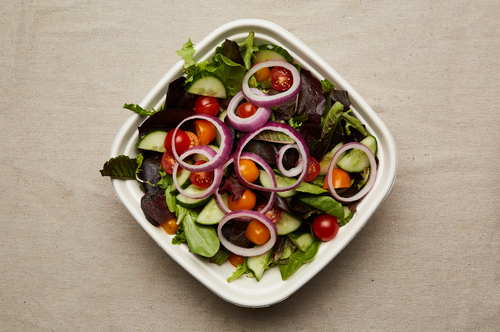 Local mixed greens seen from above with cucumber, tomato and red onion