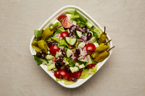 Greek salad with romaine lettuce, feta cheese, cucumber, tomato, red onion, pepperoncini, and kalamata olives.