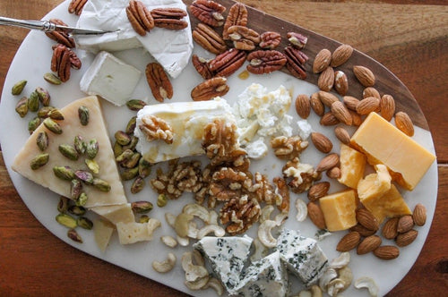 Assorted cheese and nuts on a cutting board