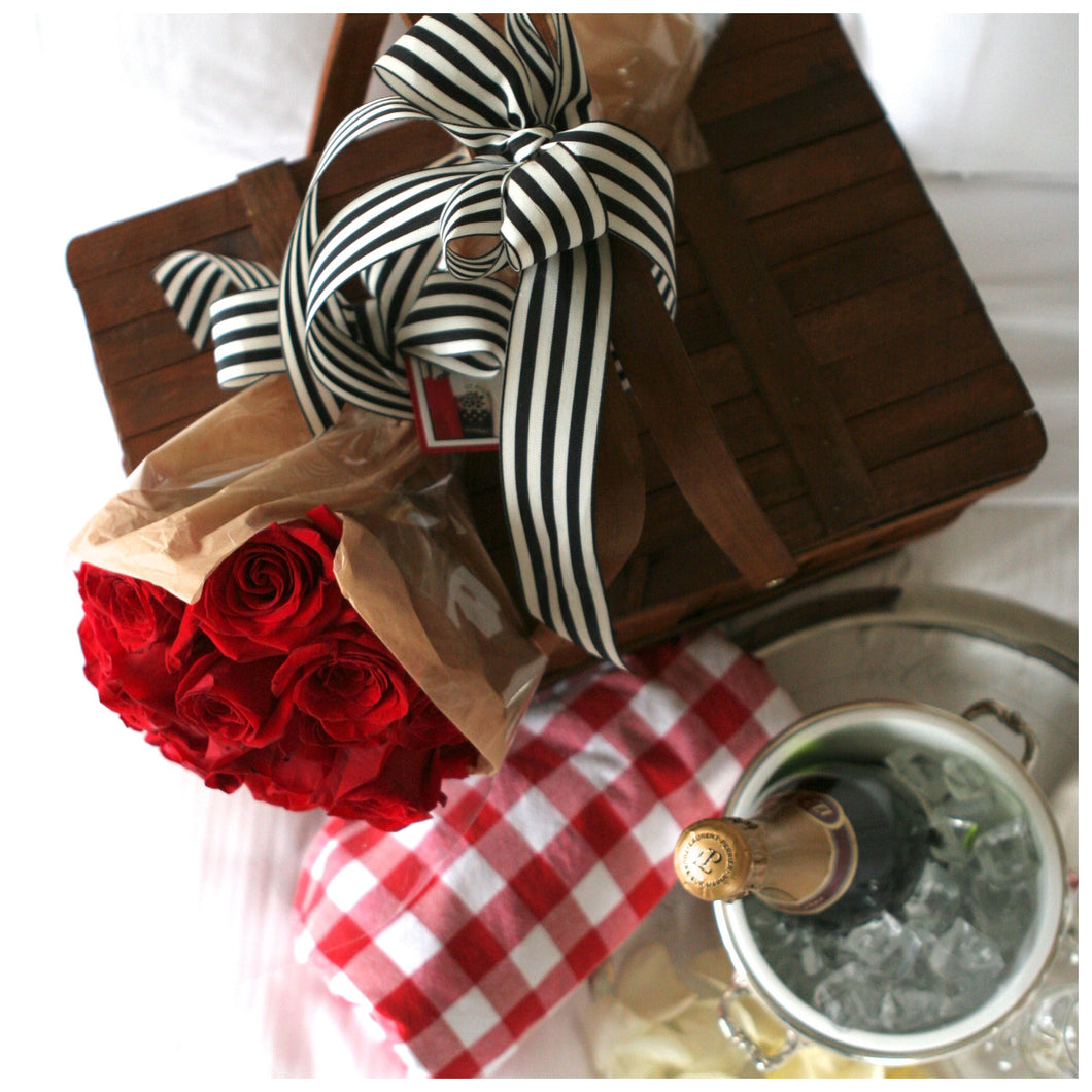 Woven picnic basket with roses and sparkling wine