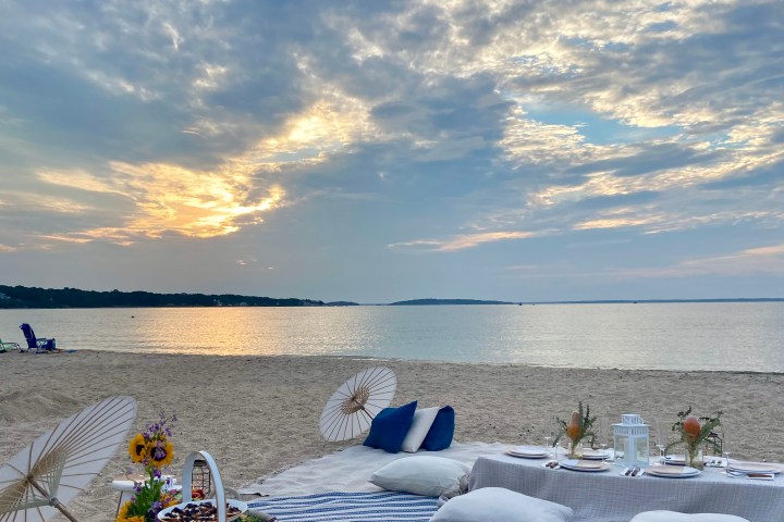 a group of people on a beach near a body of water