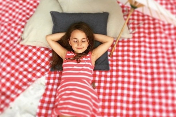 a girl in a dress lying on a bed