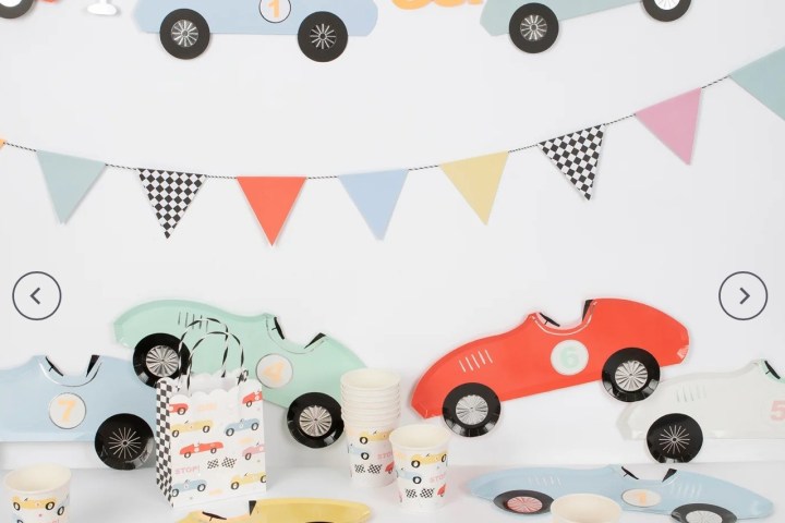 Race car-themed party decor with car plates, cups, banner, and flags.
